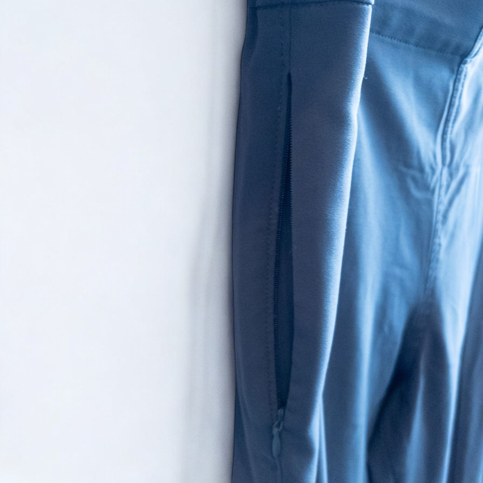 Gray MM LaFleur tech pants hanging on a hanger front and back views with close up of waistband, zipper, and label image 4