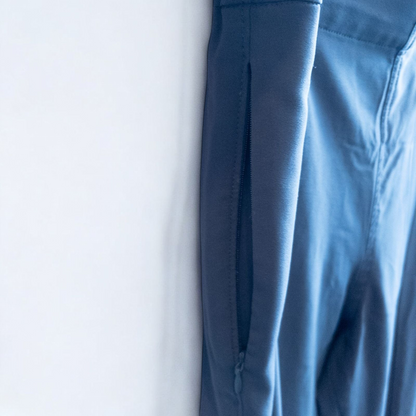 Gray MM LaFleur tech pants hanging on a hanger front and back views with close up of waistband, zipper, and label image 4