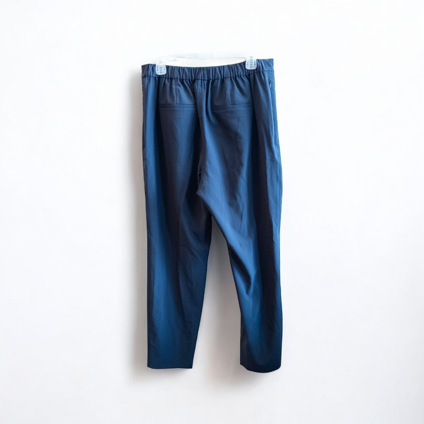 Gray MM LaFleur tech pants hanging on a hanger front and back views with close up of waistband, zipper, and label image 6