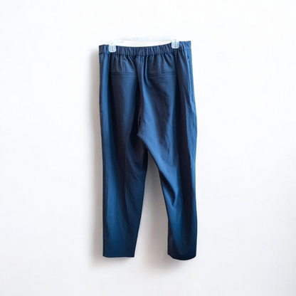 Gray MM LaFleur tech pants hanging on a hanger front and back views with close up of waistband, zipper, and label image 6