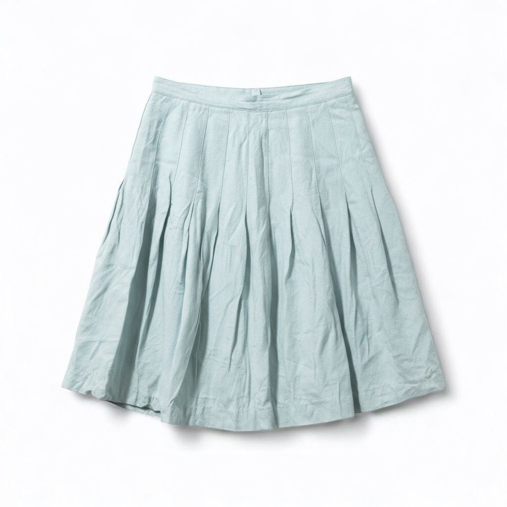 Casual Corner vintage pastel green pleated mini skirt with textured fabric hanging on clear hanger front on white muslin photography backdrop