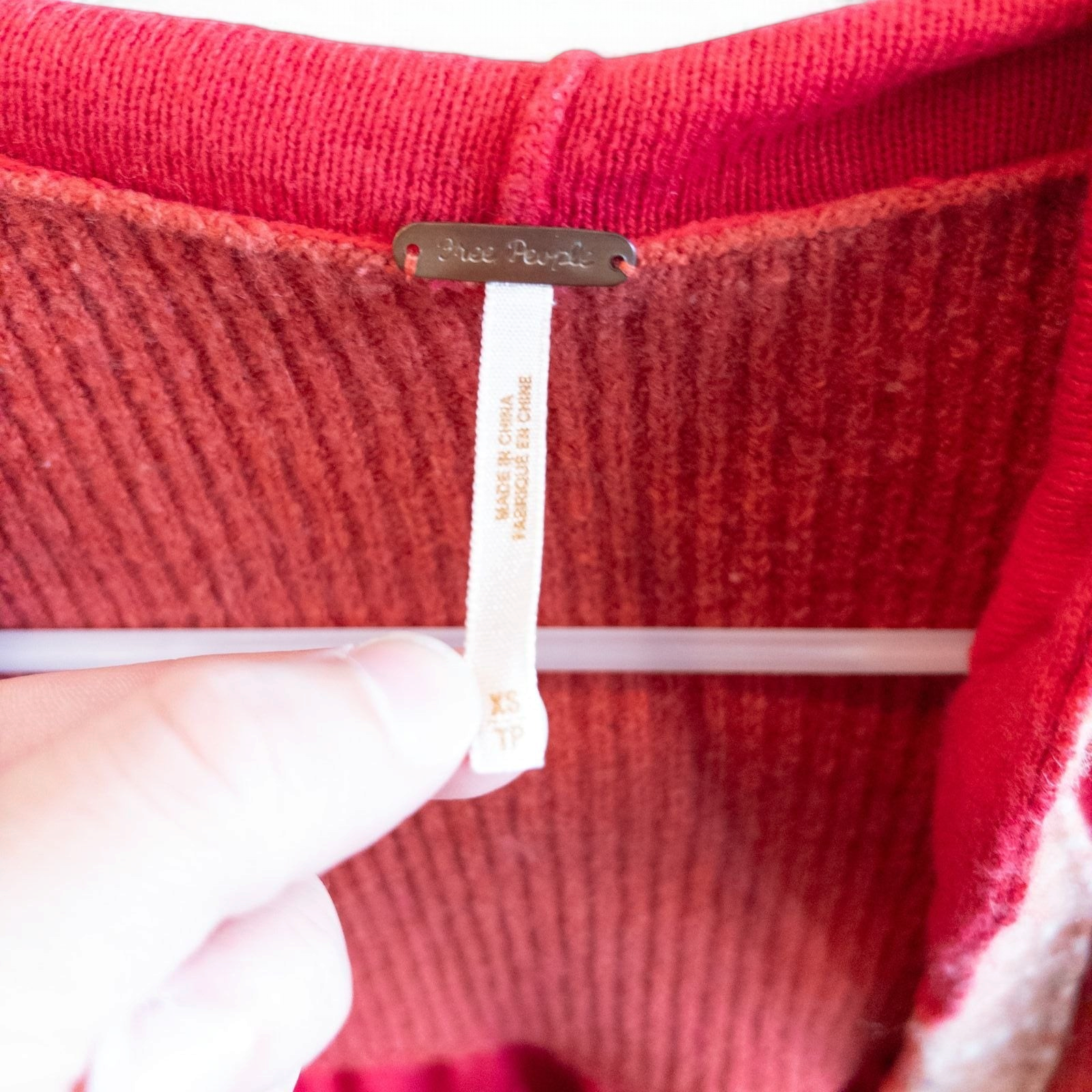 Free People red wool knit cardigan sweater with hood and button front, hung on white hanger image 9