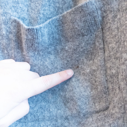 Athleta gray wool cashmere open knit sweater cardigan hanging on white door with two front pockets and ribbed cuffs, showing small brown speck on pocket and fuzzy texture image 5