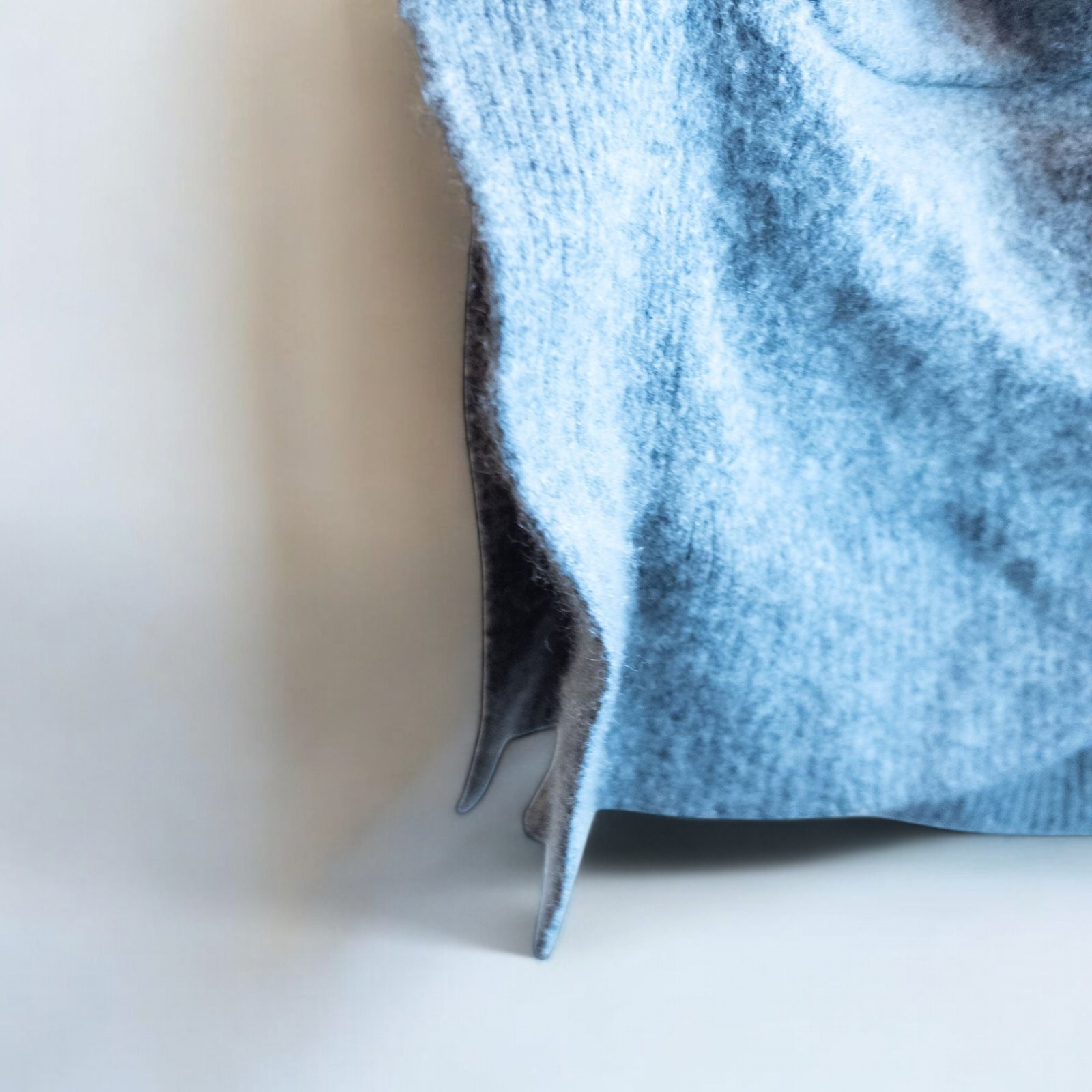 Athleta gray wool cashmere open knit sweater cardigan hanging on white door with two front pockets and ribbed cuffs, showing small brown speck on pocket and fuzzy texture image 6
