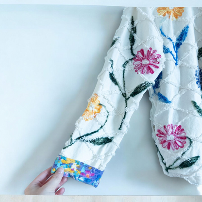 Keren Hart vintage embroidered flower jacket in white with multicolor floral embroidery on a woman and hanging on hangers image 11