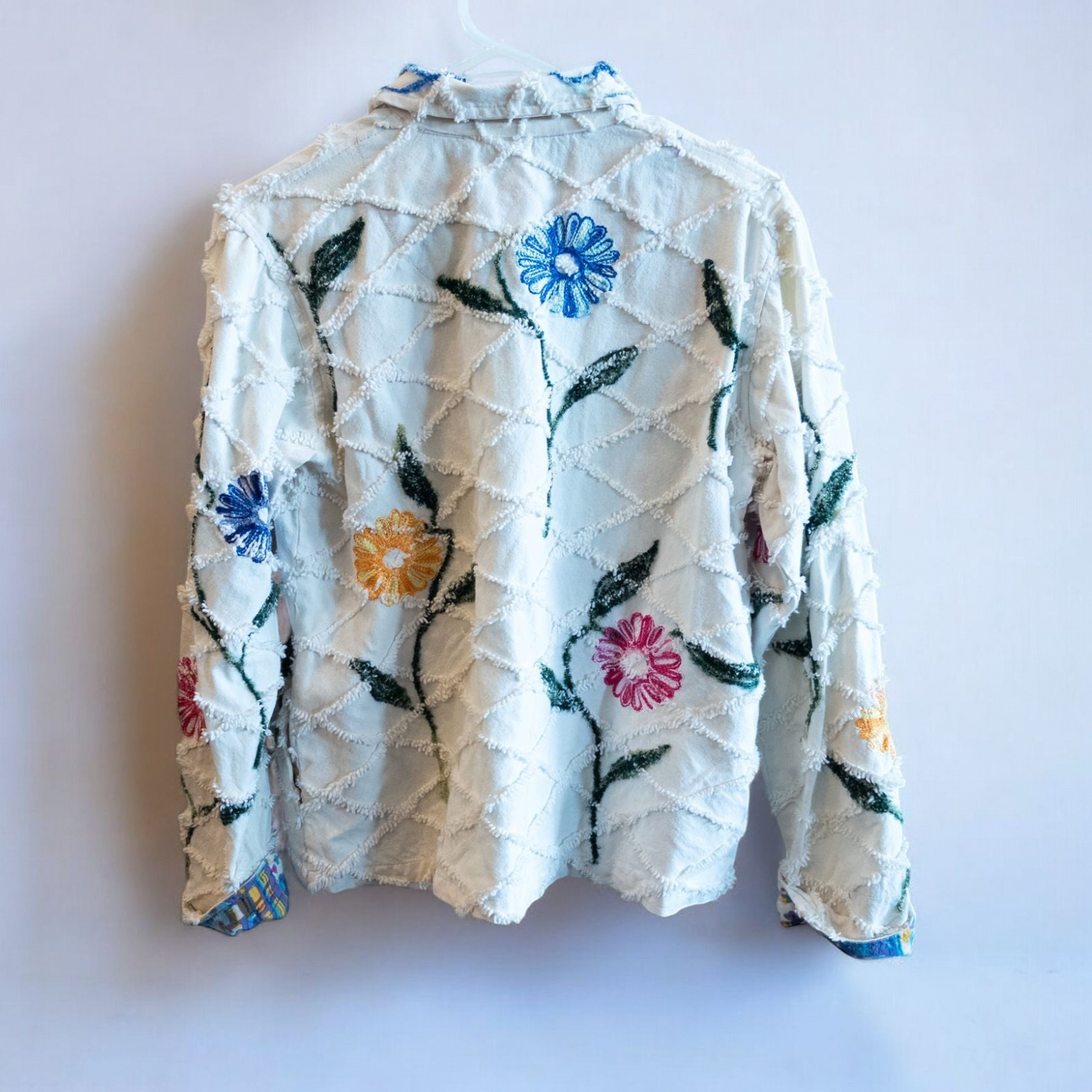 Keren Hart vintage embroidered flower jacket in white with multicolor floral embroidery on a woman and hanging on hangers image 13