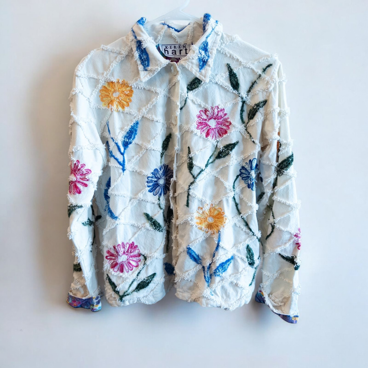 Keren Hart vintage embroidered flower jacket in white with multicolor floral embroidery on a woman and hanging on hangers