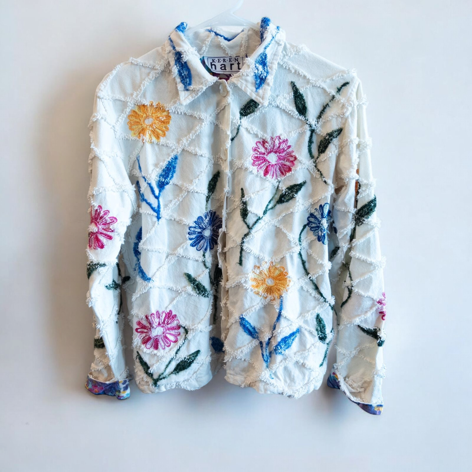 Keren Hart vintage embroidered flower jacket in white with multicolor floral embroidery on a woman and hanging on hangers