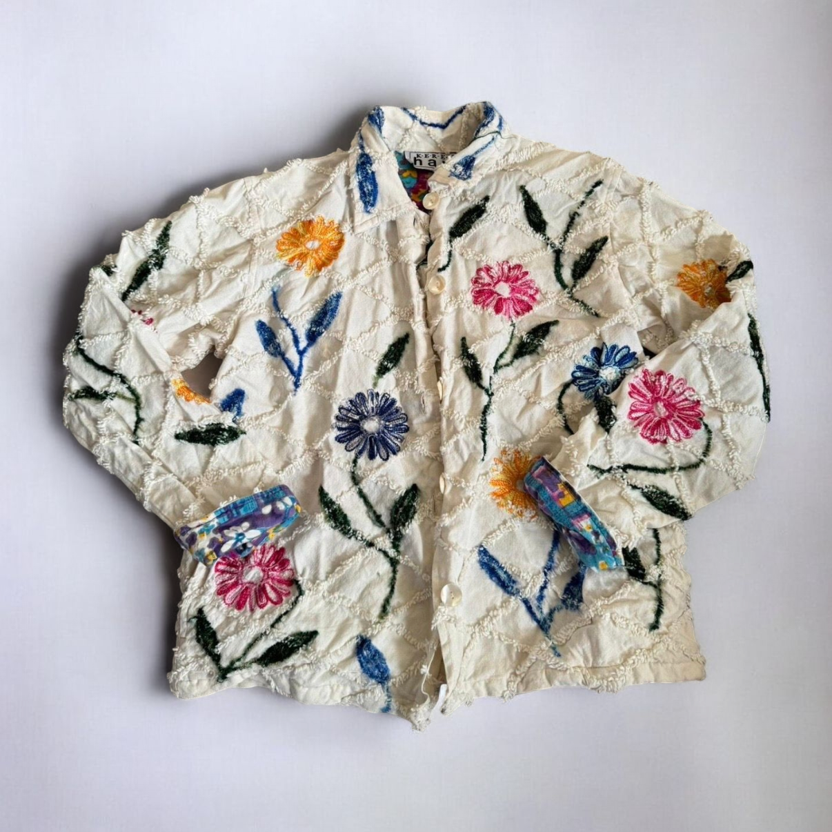 Keren Hart vintage embroidered flower jacket in white with multicolor floral embroidery on a woman and hanging on hangers image 2