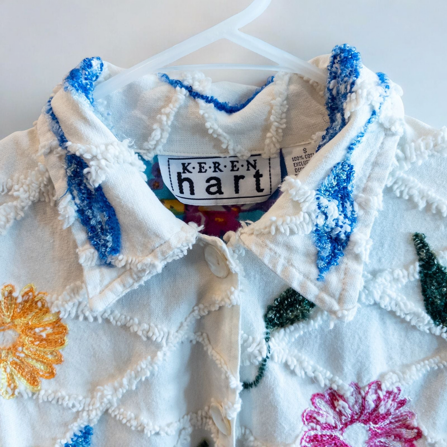 Keren Hart vintage embroidered flower jacket in white with multicolor floral embroidery on a woman and hanging on hangers image 5
