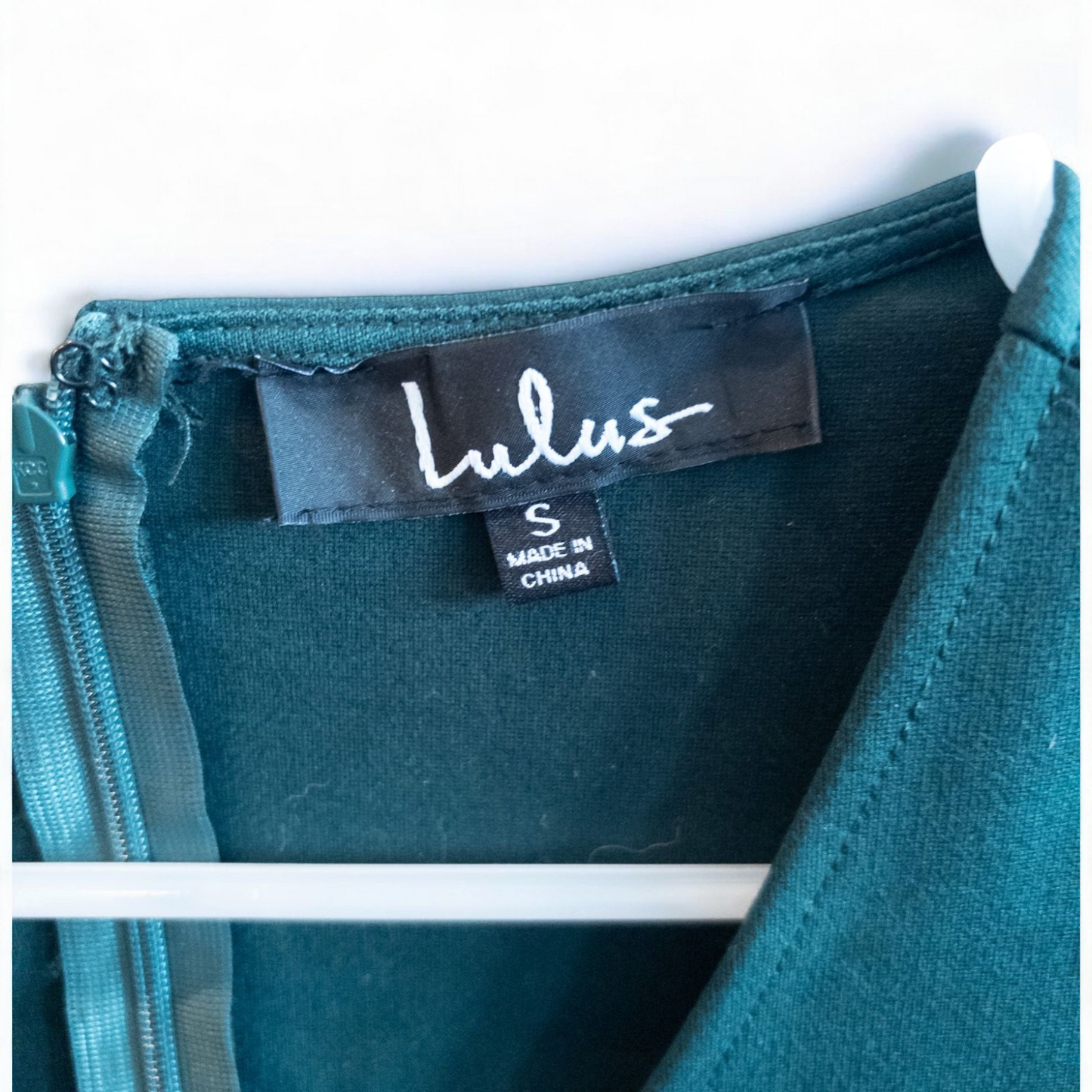 Lulus green sleeveless mini dress with deep v-neck and back zipper hanging on white hanger image 7