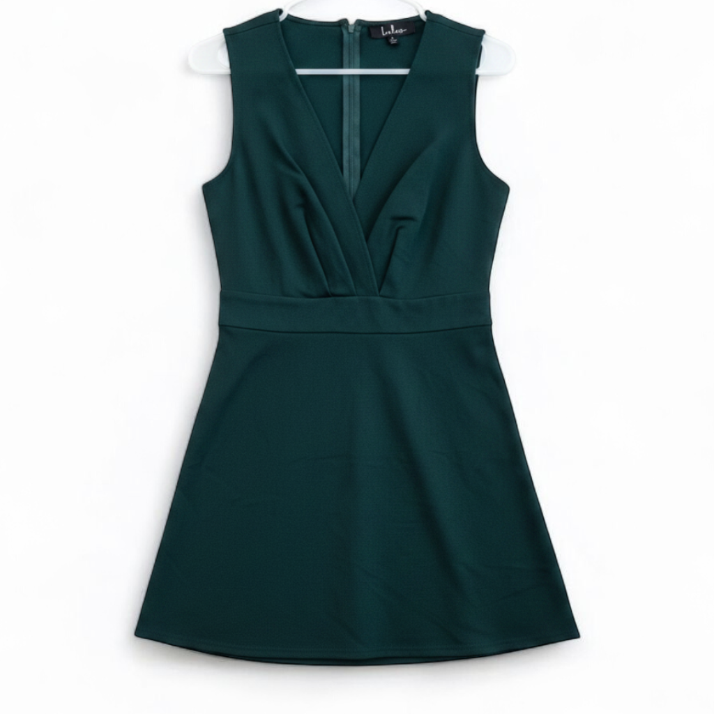 Lulus green sleeveless mini dress with deep v-neck and back zipper hanging on white hanger front on white muslin photography backdrop