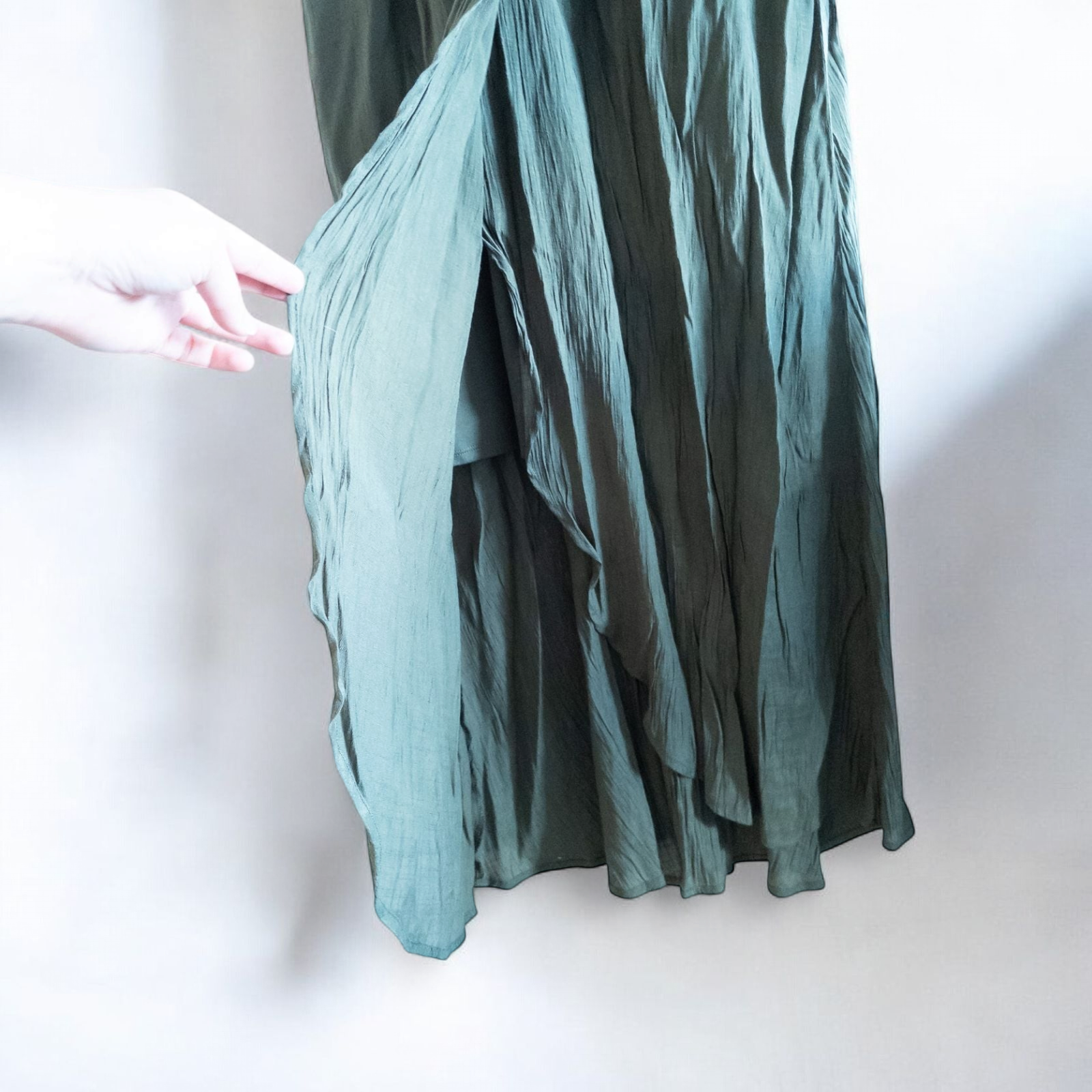 Luxology green slit maxi dress hanging on a hanger in front of a mirror image 4