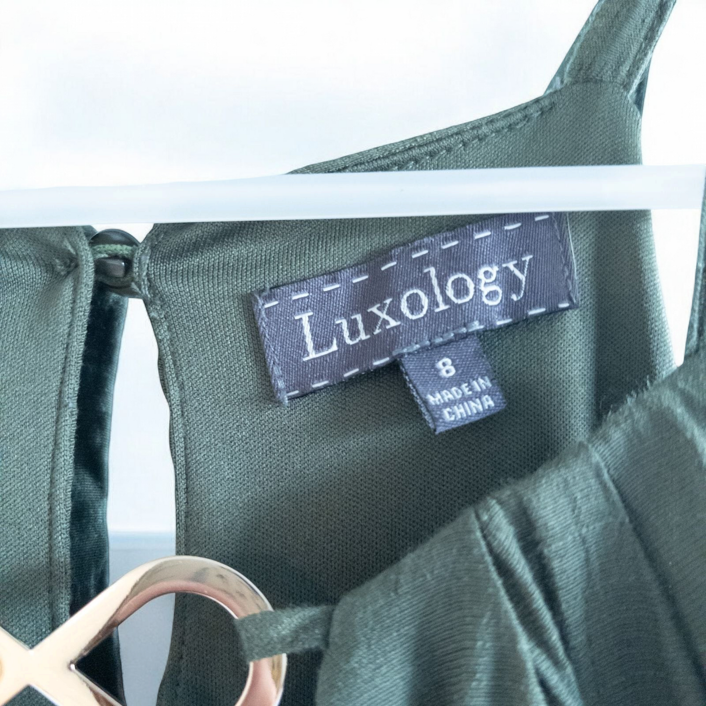 Luxology green slit maxi dress hanging on a hanger in front of a mirror image 7
