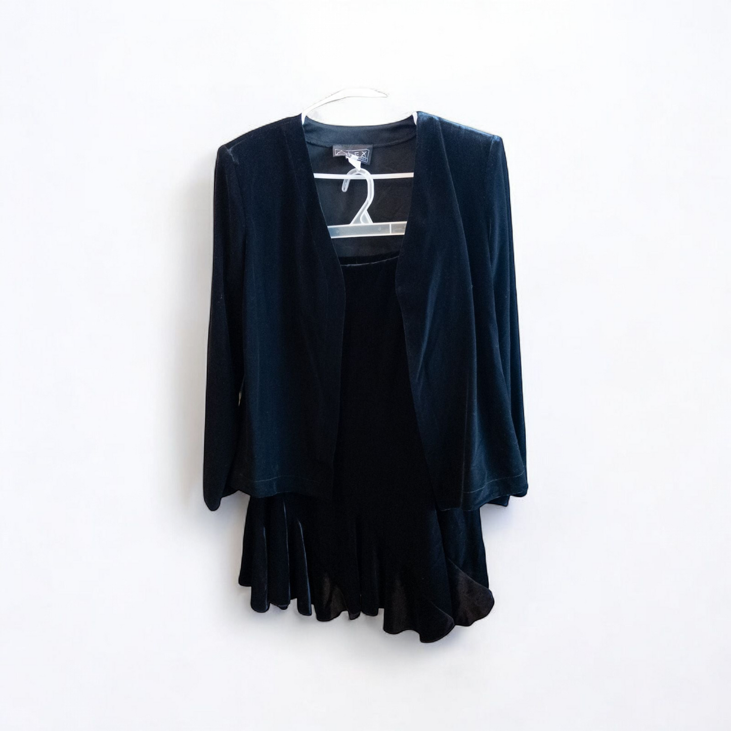Alex black velvet jacket and skirt set hanging on hanger, showing classic fitted jacket with padded shoulders and flared skirt.