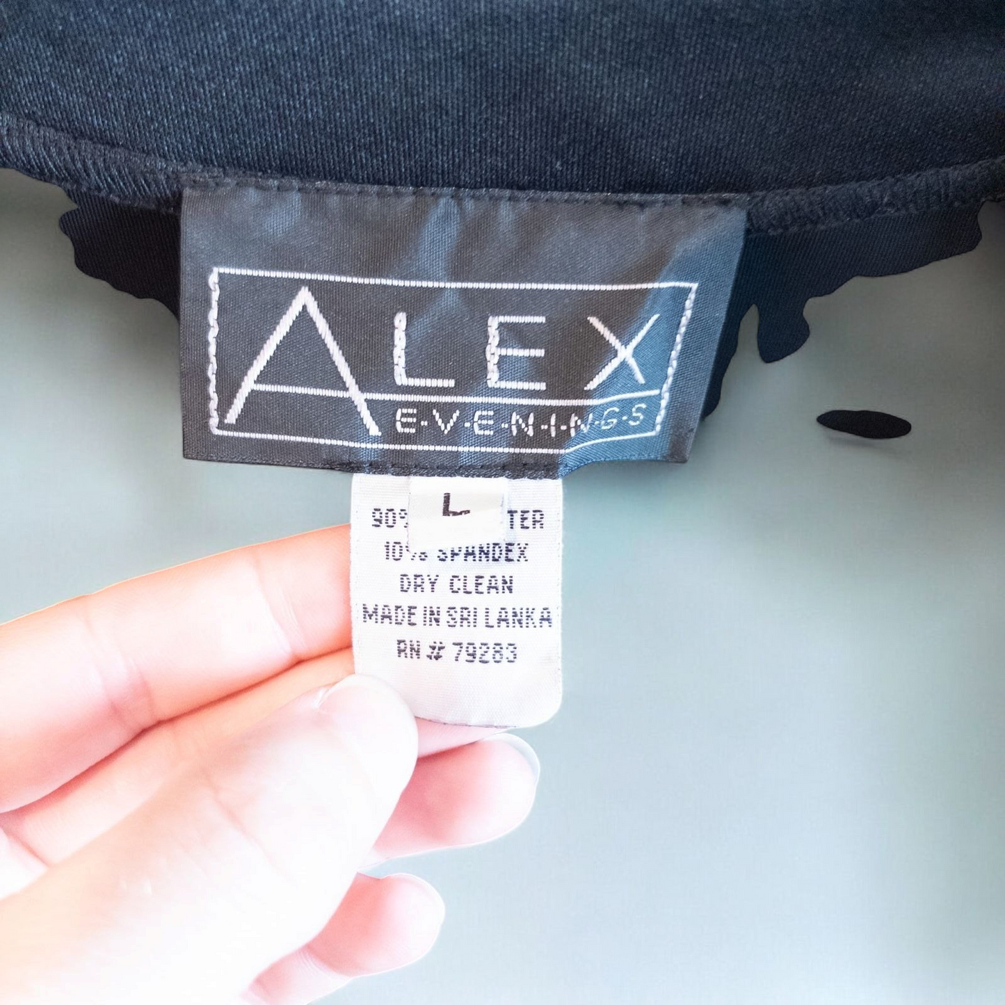 Alex black velvet jacket and skirt set hanging on hanger, showing classic fitted jacket with padded shoulders and flared skirt. image 9
