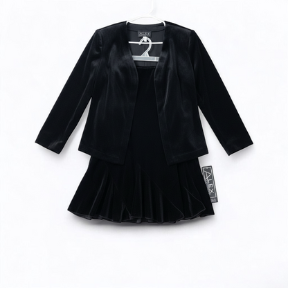 Alex black velvet jacket and skirt set hanging on hanger, showing classic fitted jacket with padded shoulders and flared skirt. front on white muslin photography backdrop