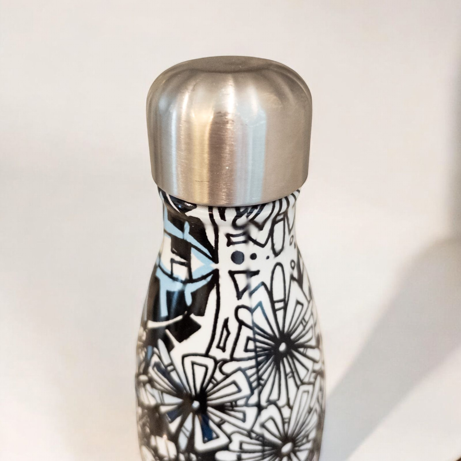Starbucks Swizzle bottle with black white and blue artistic floral abstract print on countertop image 9