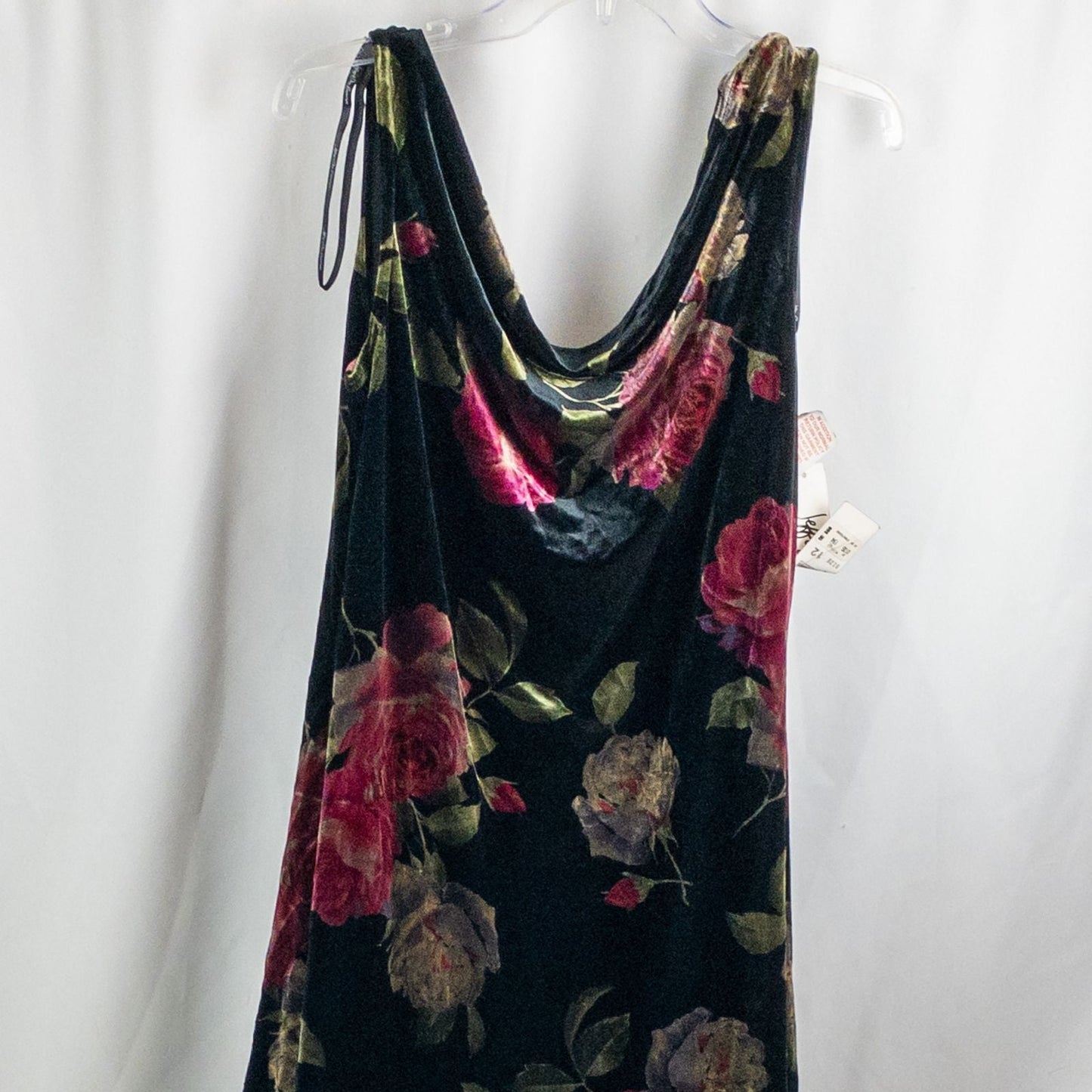 Vintage Jeffrey & Dara red rose velvet evening dress size 12 hanging in front of bookshelves showcasing black velvet fabric with red and purple rose floral pattern and cowl neckline. image 2