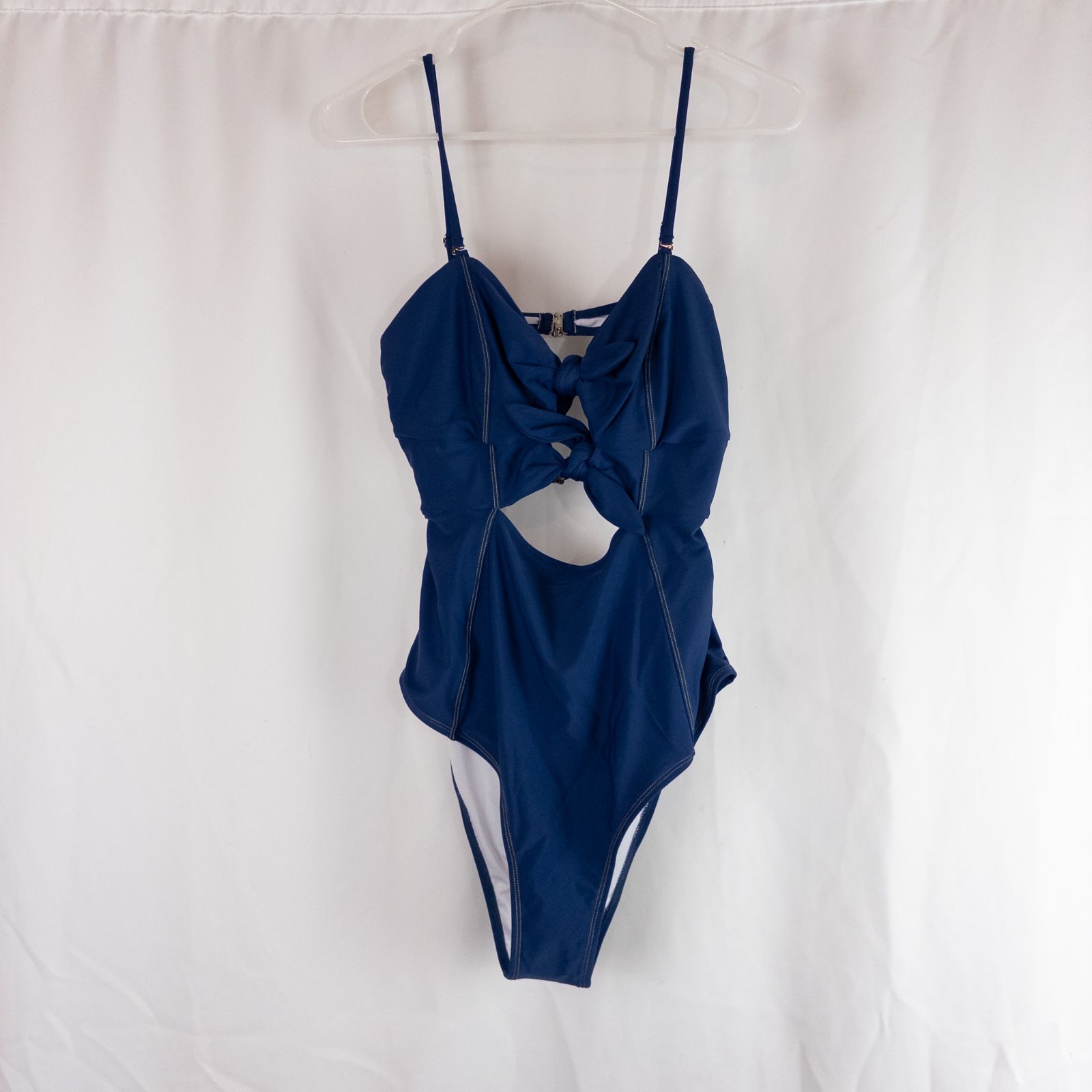 Blue Cupshe one piece swimsuit with cutout and knot detailing front view on hanger