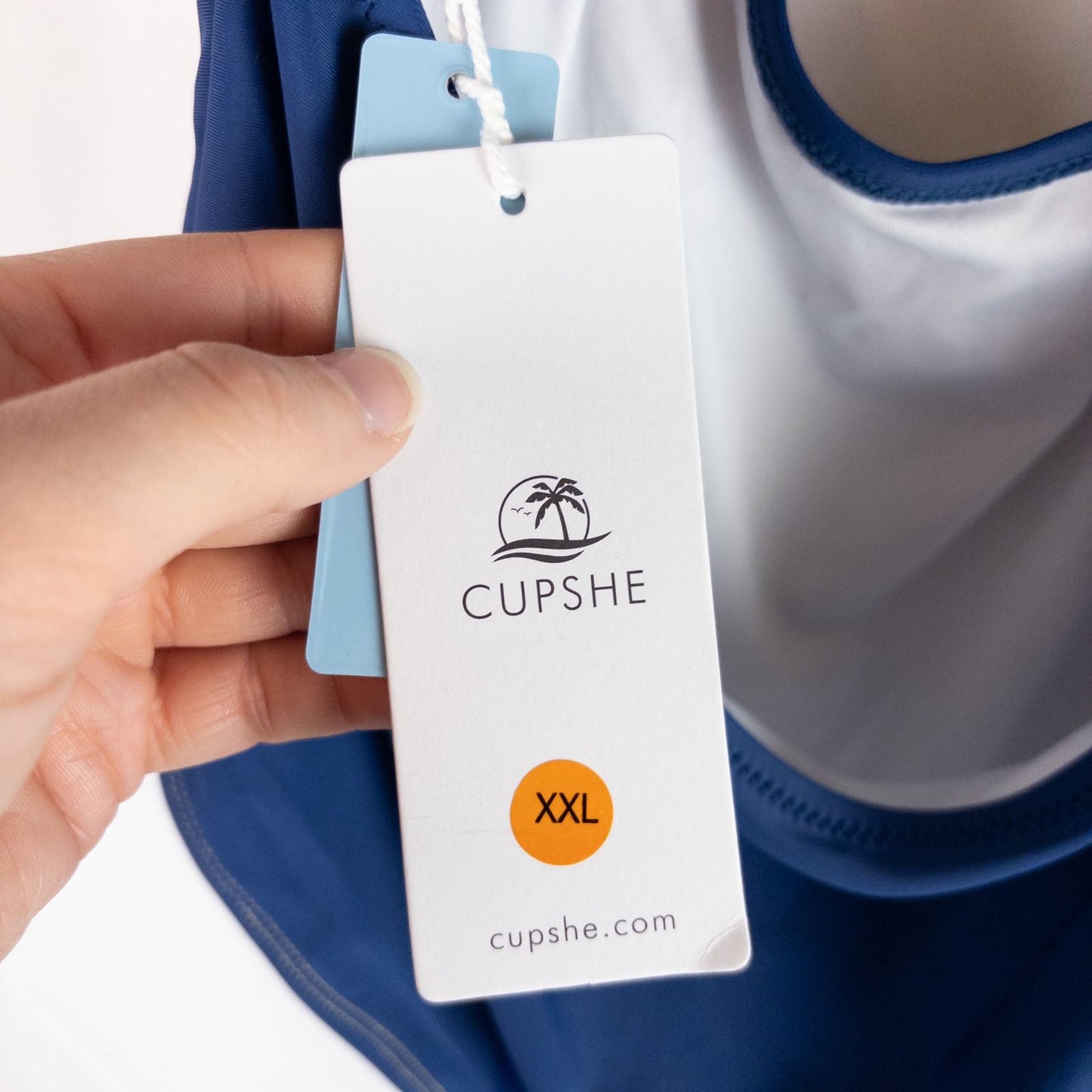 Blue Cupshe one piece swimsuit with cutout and knot detailing front view on hanger image 12