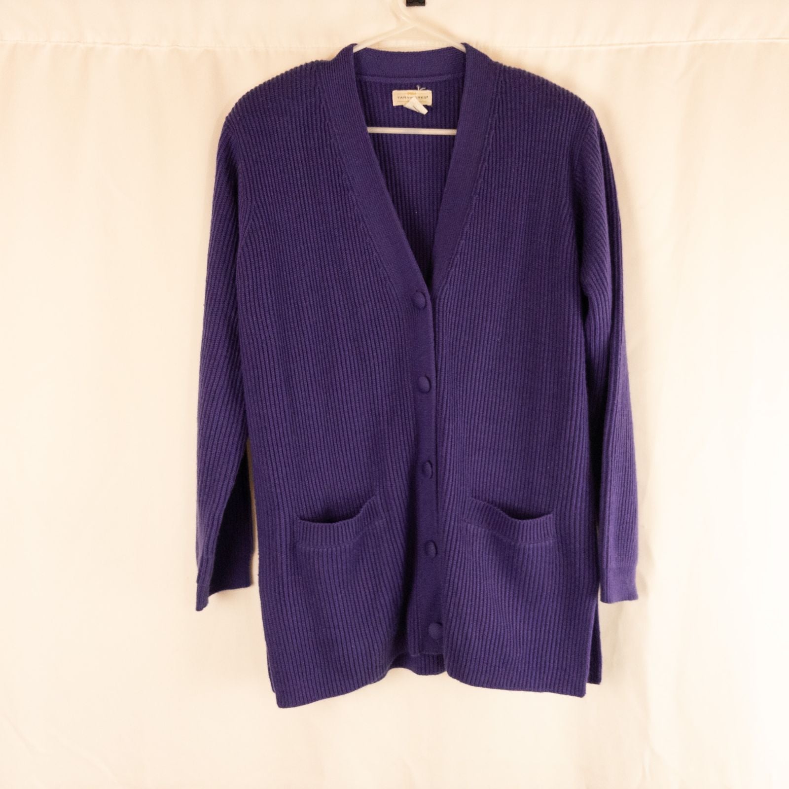 Vintage Yarnworks purple chunky knit cardigan with button front and two pockets hanging on hanger