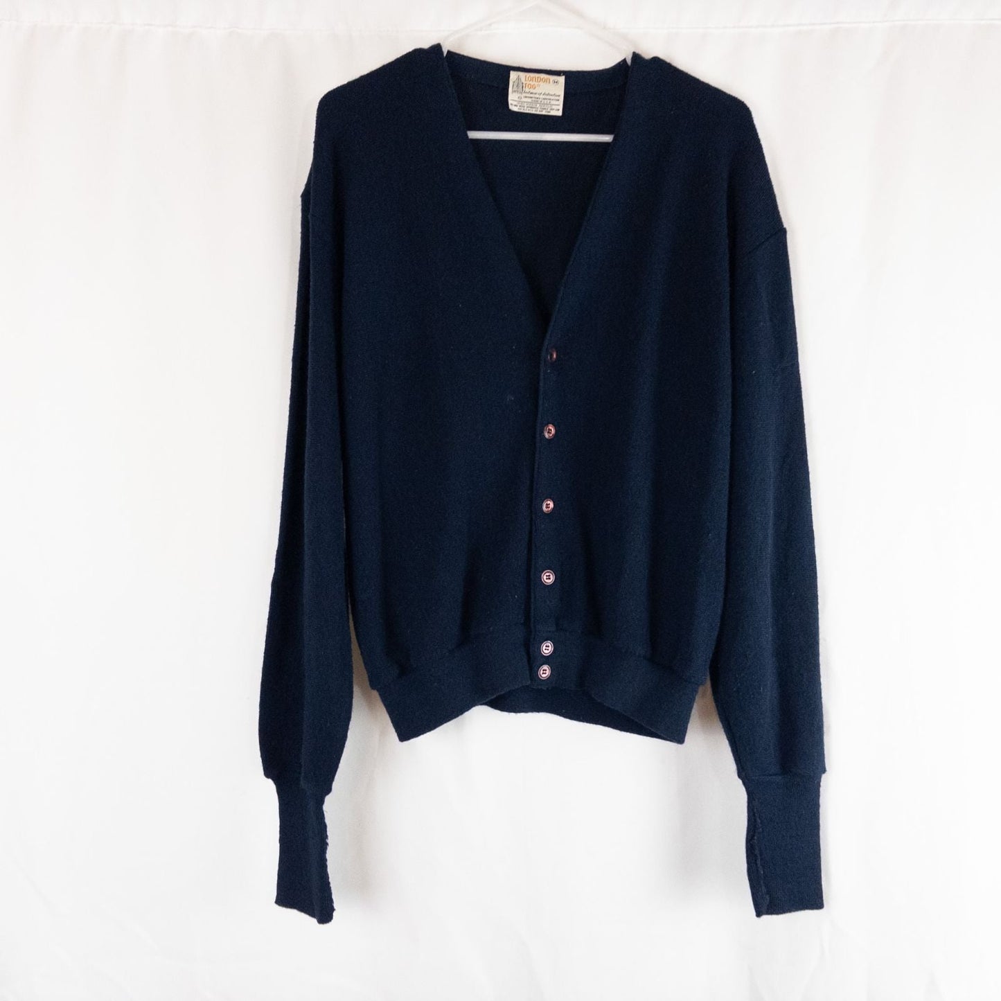 Vintage 1990s London Fog navy blue grandpa cardigan sweater with button front closure and ribbed cuffs on hanger