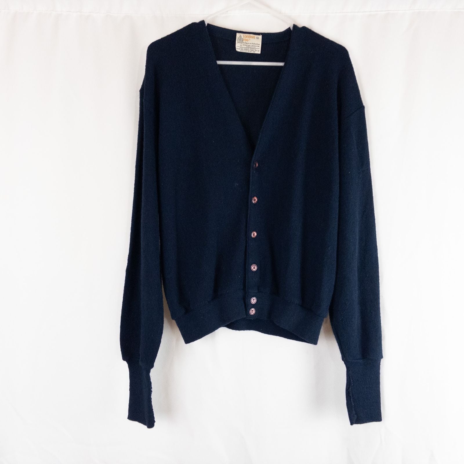Vintage 1990s London Fog navy blue grandpa cardigan sweater with button front closure and ribbed cuffs on hanger