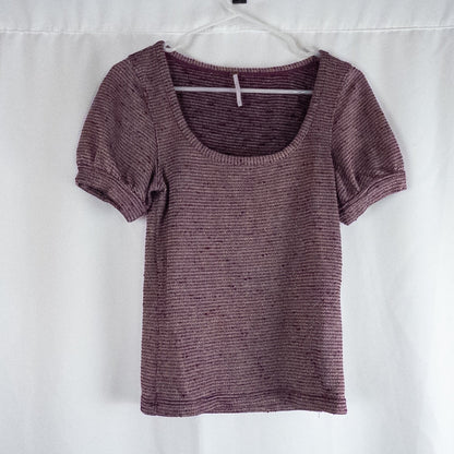 Free People knit purple and gold short puff sleeve sweater top on hanger against white background