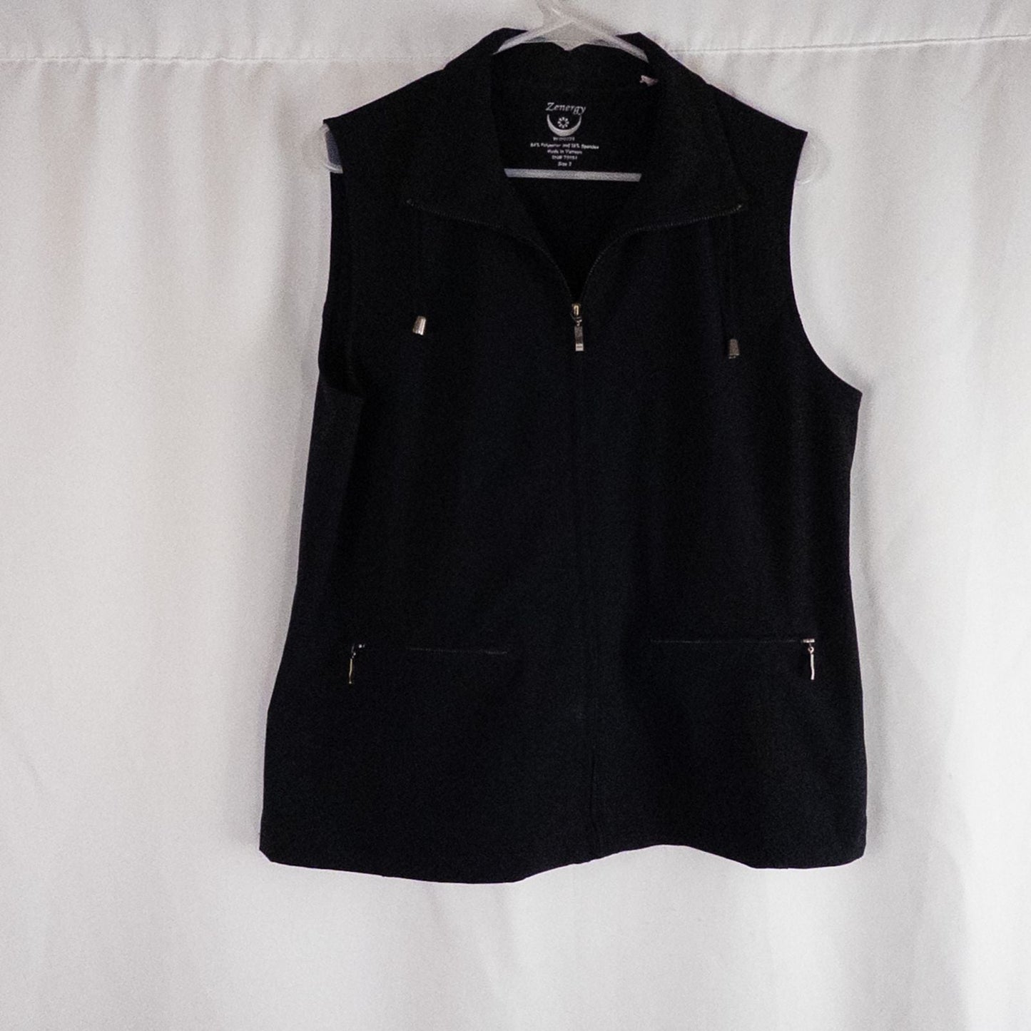 Chicos Zenergy black utility vest womens size 2 displayed on hanger showing front, back, collar, and smudge detail