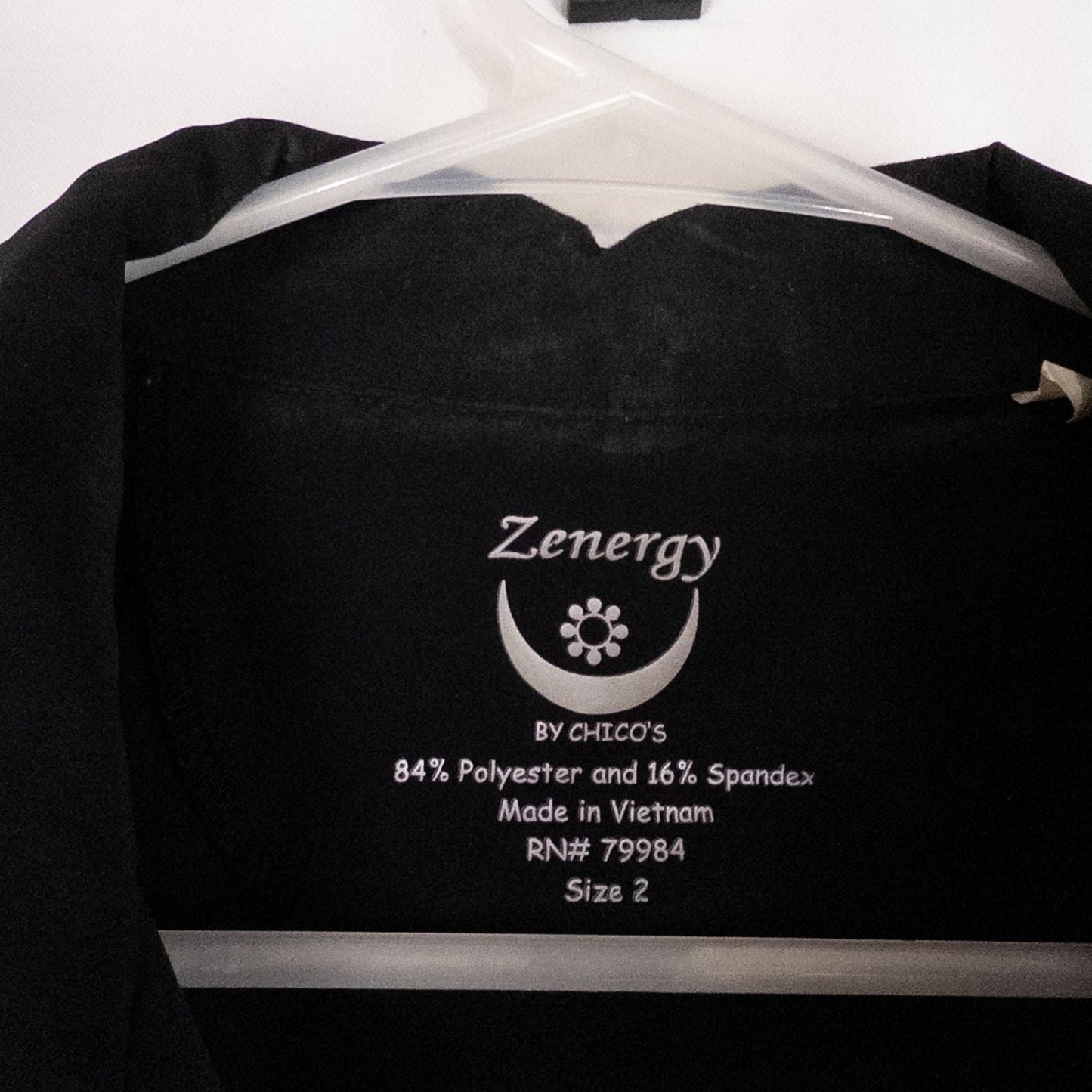 Chicos Zenergy black utility vest womens size 2 displayed on hanger showing front, back, collar, and smudge detail image 7
