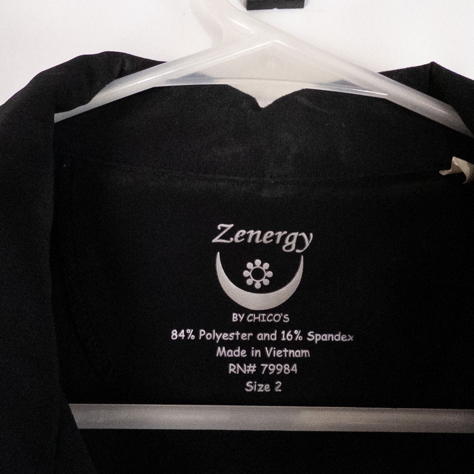 Chicos Zenergy black utility vest womens size 2 displayed on hanger showing front, back, collar, and smudge detail image 7