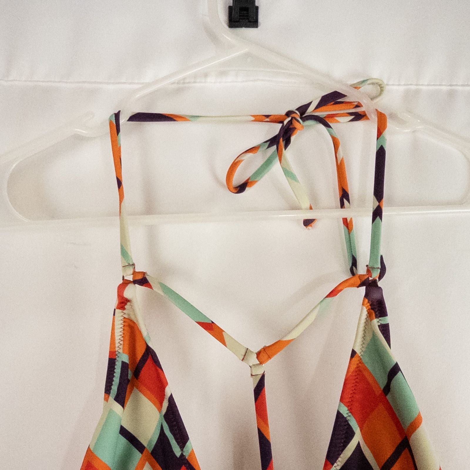 Orange teal geometric diamond pattern Cupshe one-piece swimsuit with halter neck and cutout detail shown hanging on white hanger image 5
