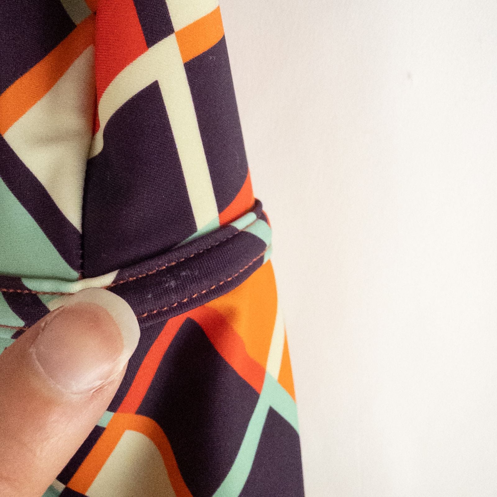 Orange teal geometric diamond pattern Cupshe one-piece swimsuit with halter neck and cutout detail shown hanging on white hanger image 4