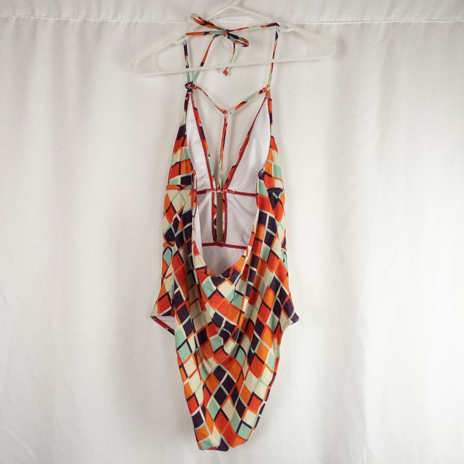Orange teal geometric diamond pattern Cupshe one-piece swimsuit with halter neck and cutout detail shown hanging on white hanger image 6