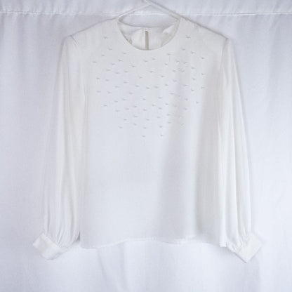 Anne Kriste vintage white sheer blouse with pearl beading on front and long sleeves with button cuffs hanging on hanger