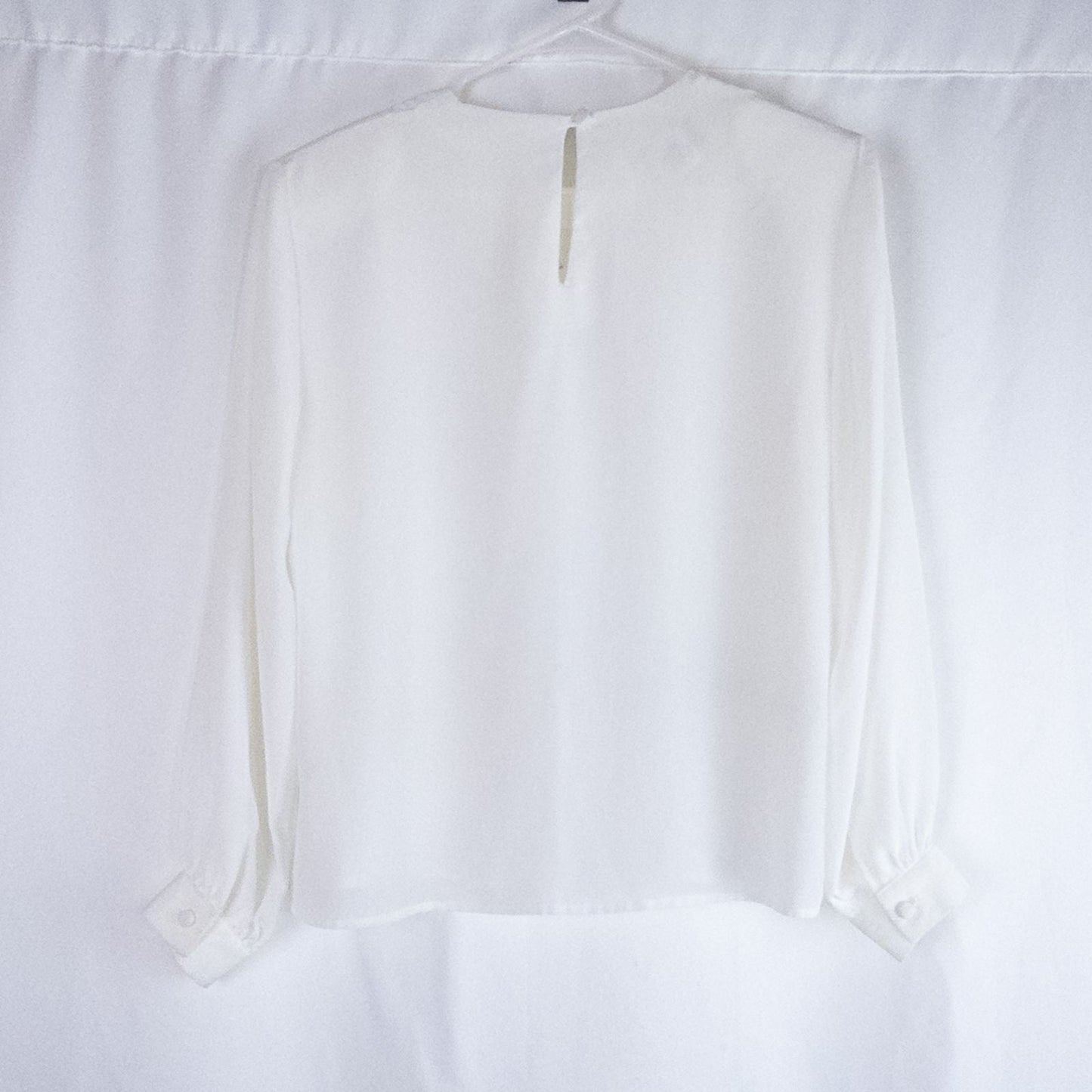 Anne Kriste vintage white sheer blouse with pearl beading on front and long sleeves with button cuffs hanging on hanger image 5