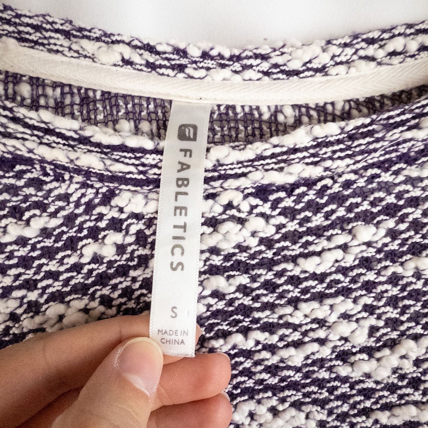 Purple and white striped open knit Fabletics sweater with textured yarn and relaxed oversized fit, shown front and close-up of knit texture and minor snags image 9