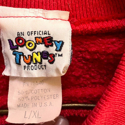 Vintage Official Looney Tunes red Louisville Tweety Bird sweatshirt with a crew neckline and ribbed cuffs laid flat on wooden floor. image 4