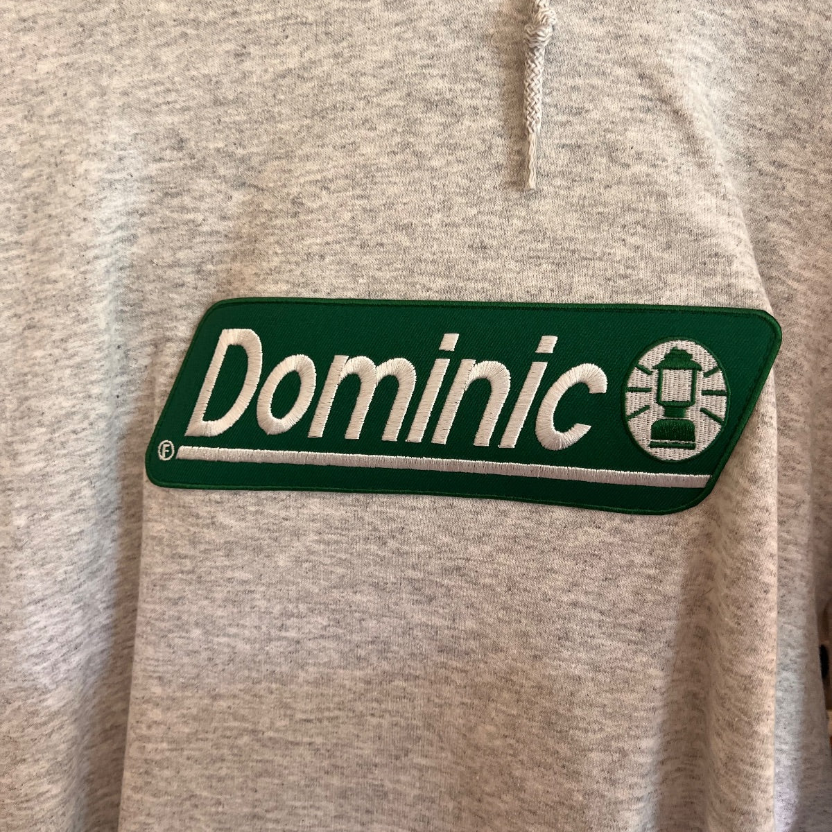 Gray Out of Order Dominic Fike band merchandise hoodie front and back views showing embroidered logo, pullover style with hood and kangaroo pocket image 4