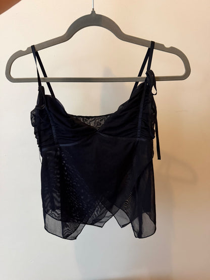 Black Shaye tank top with ruched bust and layered sheer chiffon overlay on a model and hanging on a hanger image 2