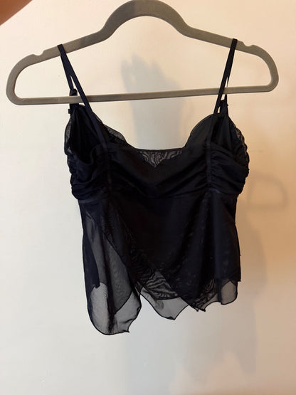 Black Shaye tank top with ruched bust and layered sheer chiffon overlay on a model and hanging on a hanger image 3