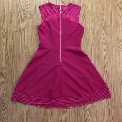 Pink sleeveless dress with sheer striped mesh panels on neckline and hem laid flat on wood floor image 5