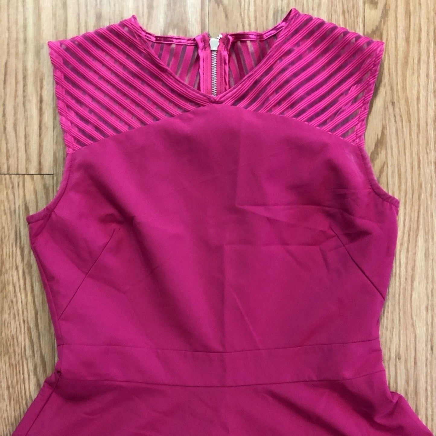 Pink sleeveless dress with sheer striped mesh panels on neckline and hem laid flat on wood floor image 2